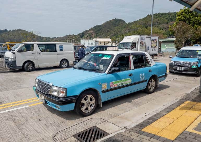 Hong Kong. China- 02.27.2025. Lantau Island blue taxis waiting at the taxi stand by Tai O bus terminus to pick up a fare.